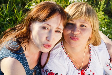 Happy women with flower relaxes in the grass with a flower.の写真素材