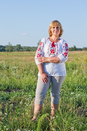 Happy woman with flower relaxes in the grass with a flower.の写真素材