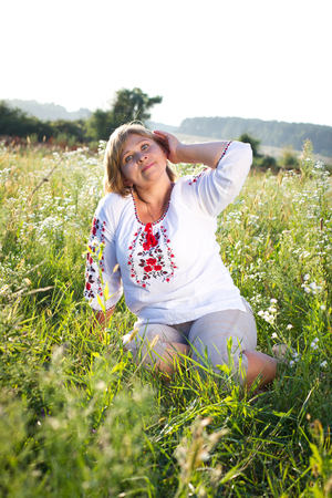 Happy woman with flower relaxes in the grass with a flower.の写真素材