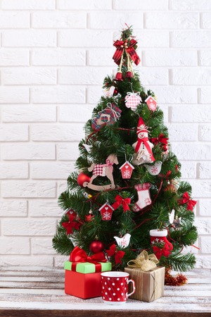 White wooden table in front of colorful christmas tree with gift boxes. Can be used for display or montage your productsの写真素材