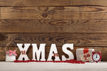 Christmas decorations. Christmas background. Watch, candle and Xmas text on wooden table.の写真素材