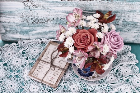 Bouquet roses and old letters on wooden desk in a vintage style.の写真素材