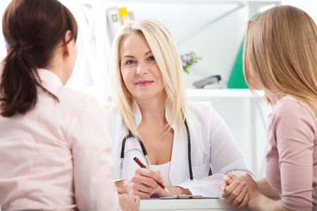 doctor explaining diagnosis to her female patientの写真素材