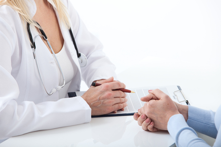 Doctor and patient are discussing something, just hands at the table close upの写真素材