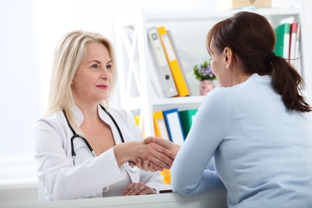 Healthcare and medical concept - doctor with patient in hospital. Handshake.の写真素材
