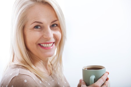 Portrait of happy blonde with mug in handsの写真素材