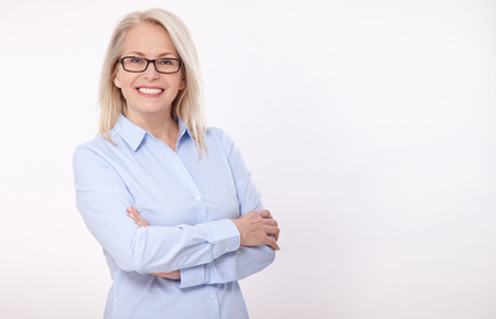 Middle aged business woman with eyeglasses in blue shirt isolated on white backgroundの写真素材