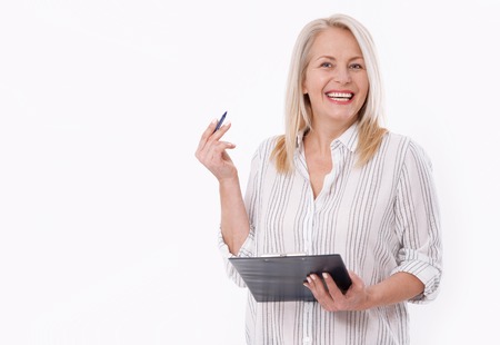 Business woman holds a pen and a folder with files isolated on white backgroundの写真素材