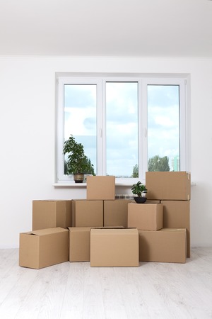 Moving into a new apartment. Move lots of cardboard boxes in an empty new apartment.の写真素材