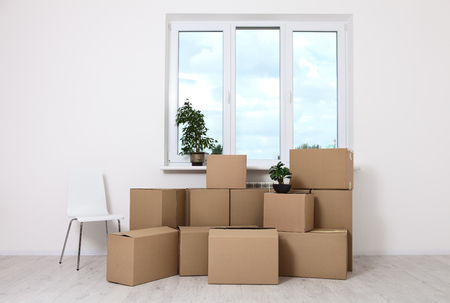 Moving into a new apartment. Move lots of cardboard boxes in an empty new apartment.の写真素材