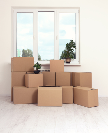 Moving into a new apartment. Move lots of cardboard boxes in an empty new apartment. Mock up.の写真素材