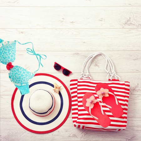 Summer accessories hat and bag on white wooden background. Mock up.の写真素材