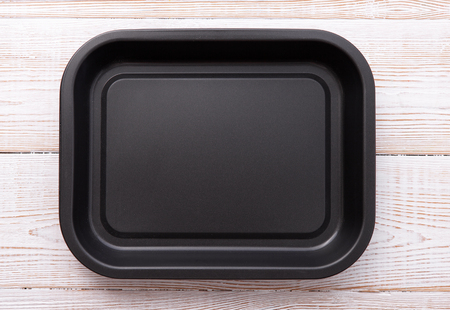 Empty baking tray for pizza close up on wooden background top view. Mock up for designの写真素材
