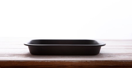 Empty baking tray for pizza close up on wooden background top view. Mock up for designの写真素材