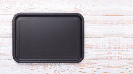 Empty baking tray for pizza close up on wooden background top view. Mock up for designの写真素材