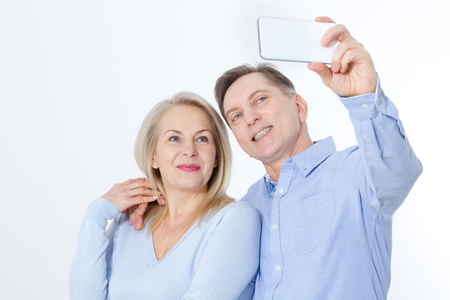 happy couple taking selfie with smartphone isolated on whiteの写真素材