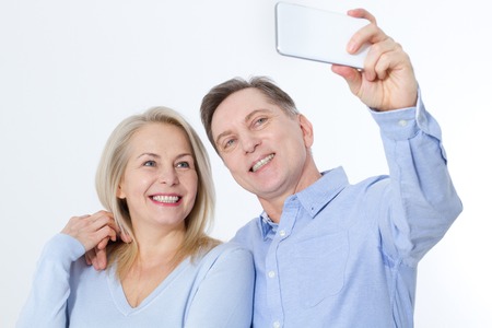 happy couple taking selfie with smartphone isolated on whiteの写真素材