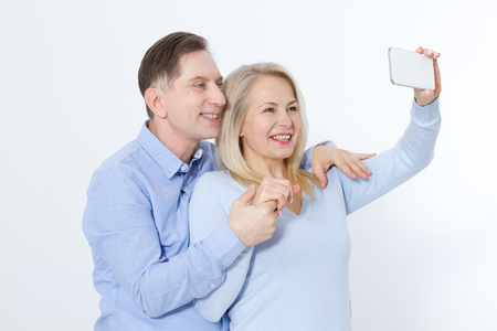 happy couple taking selfie with smartphone isolated on whiteの写真素材