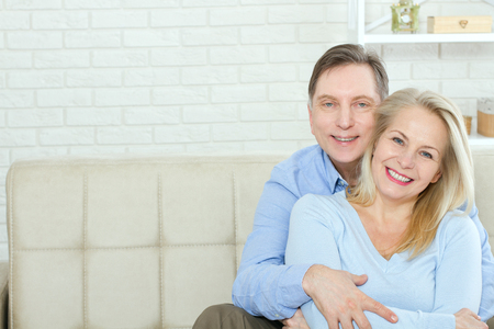 Couple at home on the couch talking and smilingの写真素材