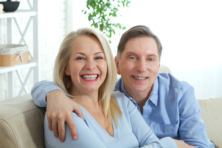 Couple at home on the couch talking and smilingの写真素材