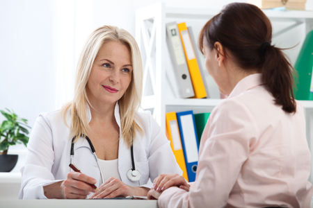Patient in the doctors office, she is receiving a prescription medicineの写真素材