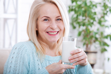 Happy middle aged woman drinking milk. Face close up.の写真素材