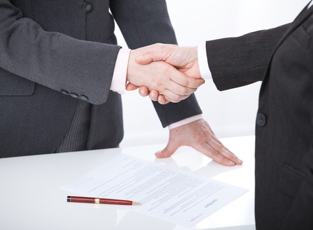 Business handshake. Two business women shake hands with each other to sign successful deal.の写真素材