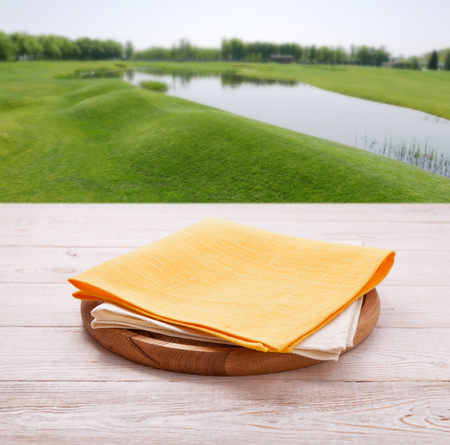 Pizza board, with tablecloth on wooden table and summer background. Top view mockupの写真素材