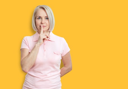 Portrait  woman with finger on lips, or secret gesture hand signの写真素材