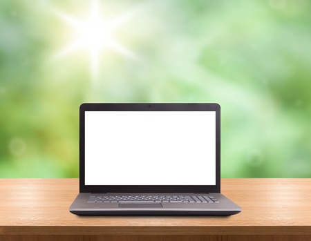 laptop with empty space on wooden table. green backgroundの写真素材