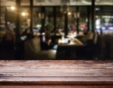 Wood table with blured background cafe , for your photo montage or product display. Space for placing items on the table.の写真素材