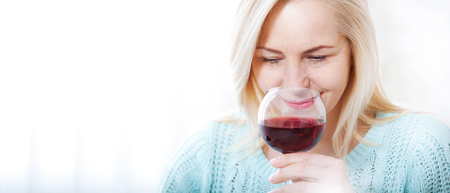 Closeup portrait of female customer drinking red wine with eyes closed.の写真素材