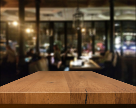 Wood table with blured background cafe , for your photo montage or product display. Space for placing items on the table.の写真素材