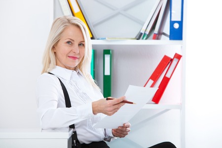 Happy business woman working in office with documentsの写真素材
