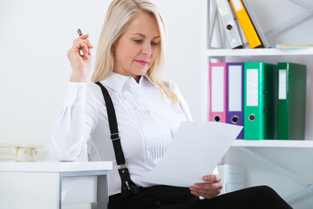 Happy business woman working in office with documentsの写真素材