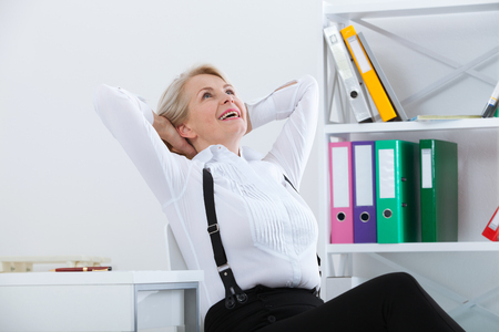 Woman relaxing in his chair and enjoying the view from office.の写真素材