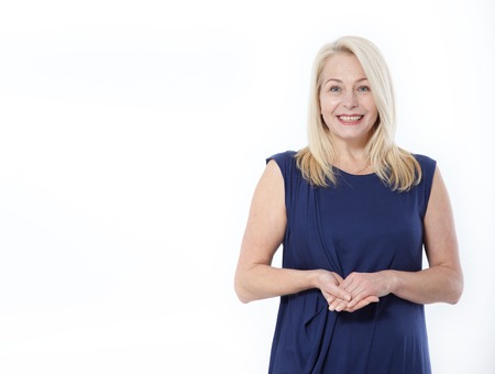 Friendly smiling middle-aged woman i in blue dress isolated on white backgroundの写真素材