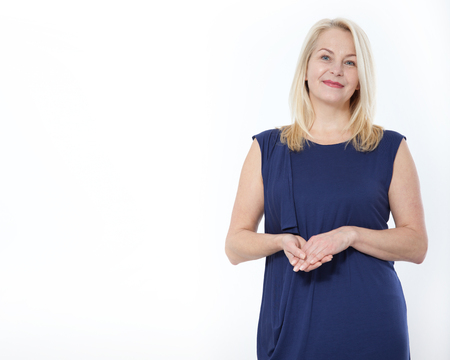 Friendly smiling middle-aged woman i in blue dress isolated on white backgroundの写真素材