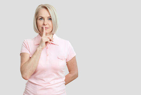 Portrait  woman with finger on lips, or secret gesture hand signの写真素材