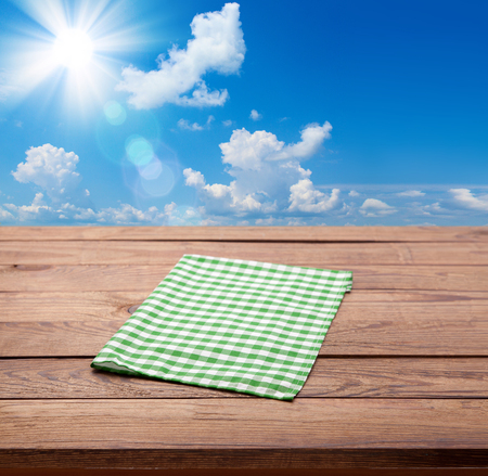 Wooden deck table with towel over summerの写真素材