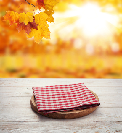 Napkin. Stack of colorful dish towels on wooden table and autumnの写真素材