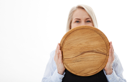 Attractive woman gives empty pizza board for your advertising products isolated on whiteの写真素材
