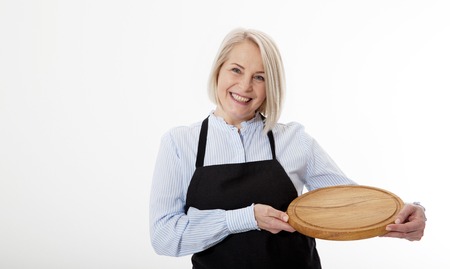 Attractive woman gives empty pizza board for your advertising products isolated on whiteの写真素材