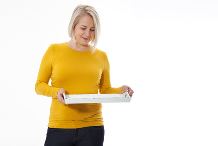 Woman gives empty tray for your advertising products isolated on whiteの写真素材