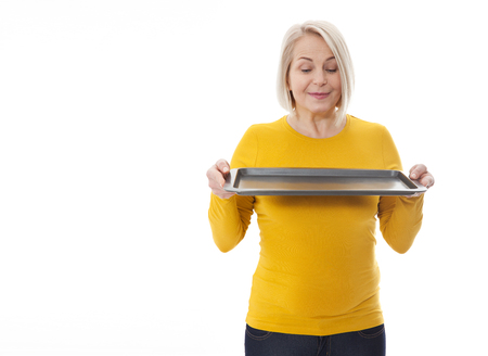 Woman gives empty tray for your advertising products isolated on whiteの写真素材