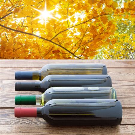 Red wine bottles stacked on wooden table.の写真素材