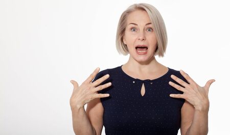 Happy woman emotionally posing in studio. Middle aged woman on white backgroundの写真素材