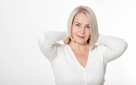 Happy woman emotionally posing in a studio. Happy woman in yellow bright sweater on white backgroundの写真素材