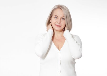 Happy woman emotionally posing in a studio. Happy woman in yellow bright sweater on white backgroundの写真素材