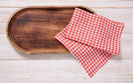 Black plate or tray, or pizza board, with tablecloth on wooden table. Top view mockupの写真素材